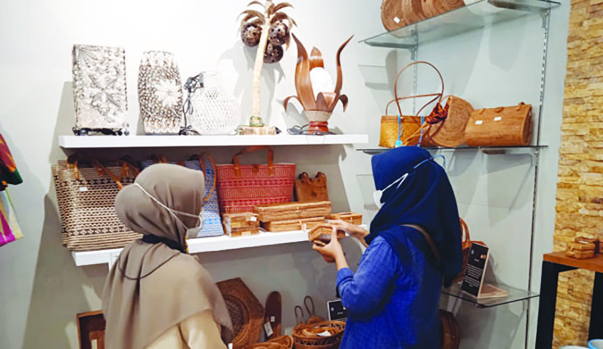 SIAP DIEKSPOR: Seorang karyawan NTB Mall melayani pengunjung yang sedang memilih koleksi kerajinan ketak lokal, Selasa (6/4/2021). (Eka/Lombok Post)