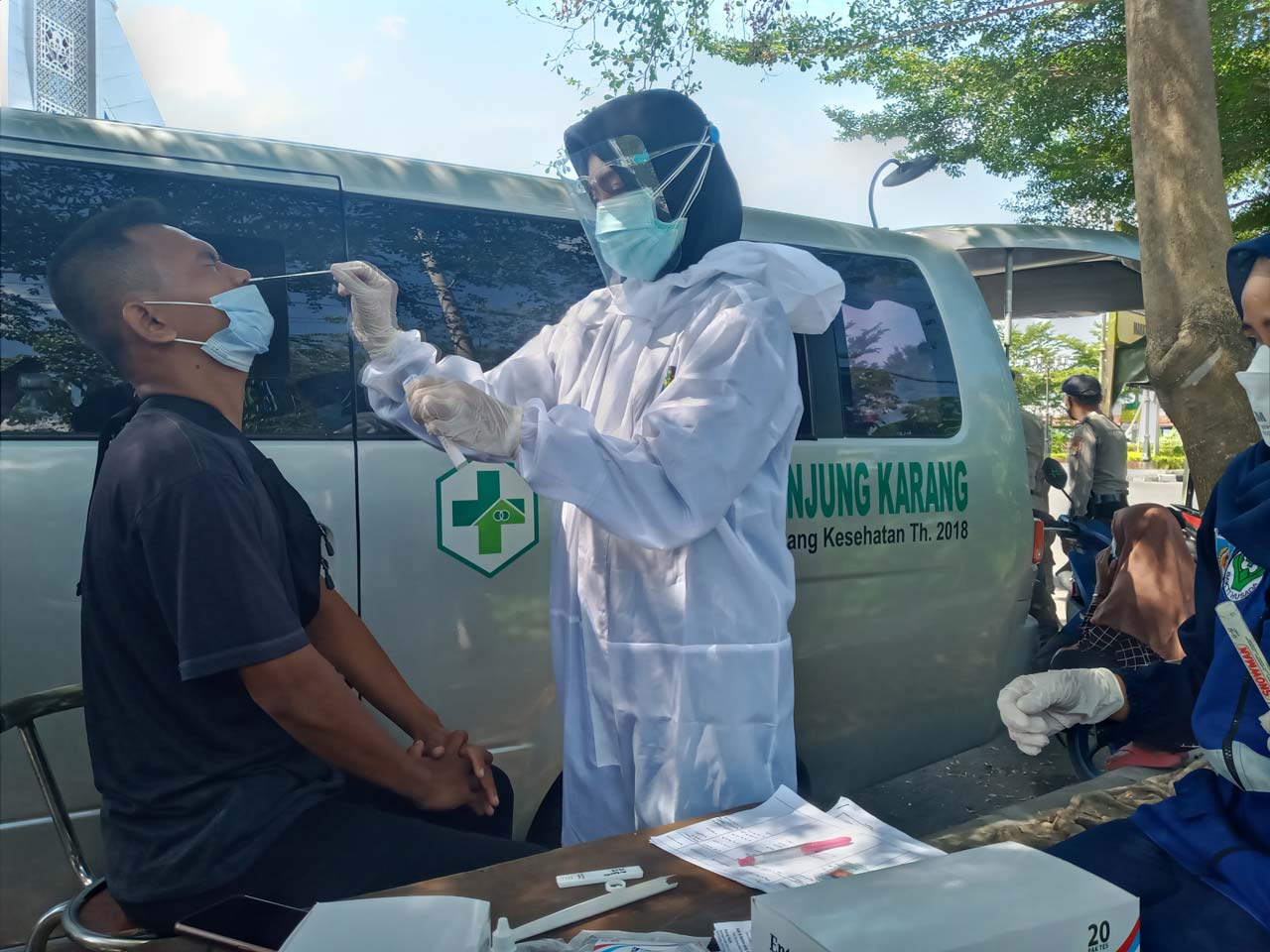 LANGKAH ANTISIPASI: Tenaga kesehatan Puskesmas Tanjung Karang melakukan rapid test bagi pengendara yang melintas di Bundaran Mataram Metro, kemarin. Ini dilakukan sebagai upaya mencegah penularan Covid-19.