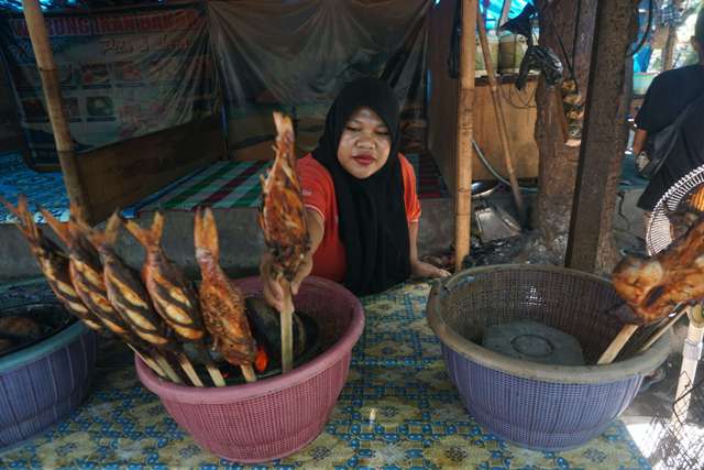 TERLANJUR JUALAN: Pedagang ikan di objek wisata pantai Labuhan Haji menaruh ikan bakarnya di perapian, Kamis (20/5). Ditutupnya objek wisata menyebabkan kerugian bagi para pedagang yang sudah terlanjur memesan ikan. (Fatih/Lombok Post)