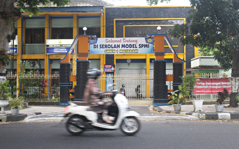 AKAN DIRELOKASI: Seorang pengendara melintas di depan SMKN 1 Mataram, Senin (17/5/2021). (Yuyun/Lombok Post)