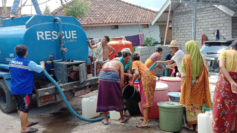 BANTU WARGA: Pegawai Dinsos NTB mendistribusikan air bersih untuk masyarakat yang terdampak kekeringan di wilayah Lombok Timur, beberapa waktu lalu. (Dok/Lombok Post)