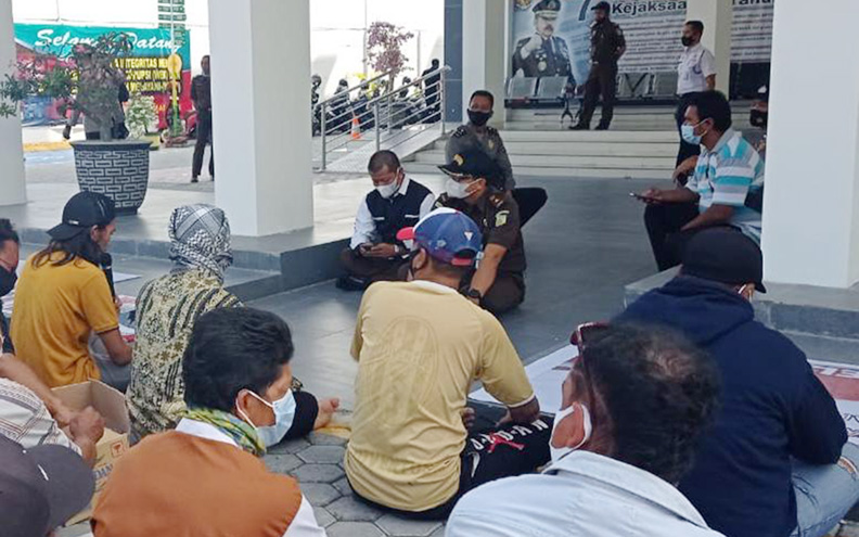 BERIKAN PENJELASAN: Kasi Intelijen Kejari Mataram Heru Sandika Triyana (tengah/topi hitam) menemui masyarakat yang melakukan demo terkait dugaan penjualan aset Desa Senteluk, di depan kantor Kejari Mataram, Senin (14/6). (IST/Lombok Post)