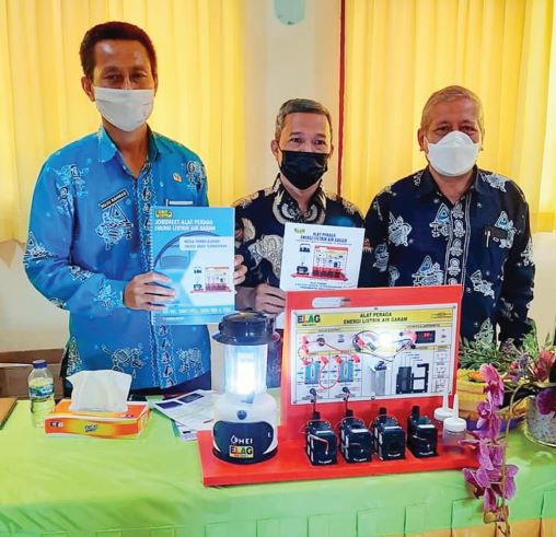 INOVASI BARU: Kepala SMKN 3 Mataram Ruju Rahmad (kiri) memperlihatkan cara kerja lampu air garam di sekolah setempat, belum lama ini. (Ist/Lombok Post)