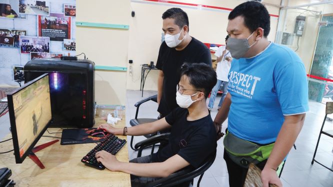 NONTON FINAL: Ketua Harian ESI NTB Hafid Hasyim (kiri) menyaksikan pertandingan final divisi Free Fire yang dilakukan secara online, kemarin (7/7).( PUJO/LOMBOK POST)