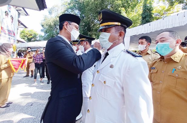 DAPAT AMANAH BARU: Wali Kota Mataram H Mohan Roliskana saat melantik Camat Cakranegara Irfan Syafindra Soerati saat acara mutasi di halaman Kantor Wali Kota Mataram, kemarin (29/6).( TONI/LOMBOK POST)