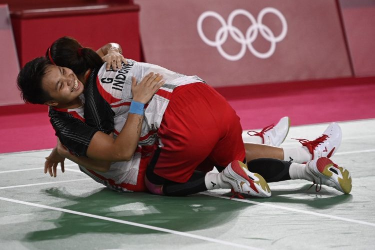 Greysia Polii/Apriyani Rahayu merayakan keberhasilan meraih emas Olimpiade Tokyo 2020. (Alexander Nemenov/AFP)