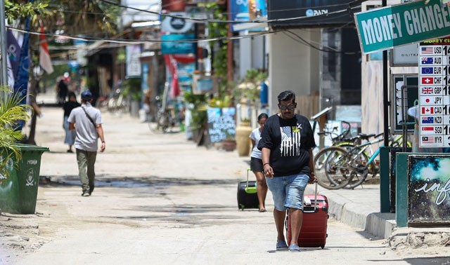 Seorang turis asing menggeret kopernya menuju pelabuhan penyebrangan Gili Trawangan, Lombok Utara. (DOK. IVAN MARDIANSYAH/LOMBOK POST)