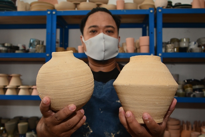 Perajin keramik menyelesaikan pembuatan keramik di workshop Damdam Keramik Studio di Pondok Aren, Kota Tangerang Selatan, Banten, Rabu (24/1/2021). (Dery Ridwansah/ JawaPos.com)