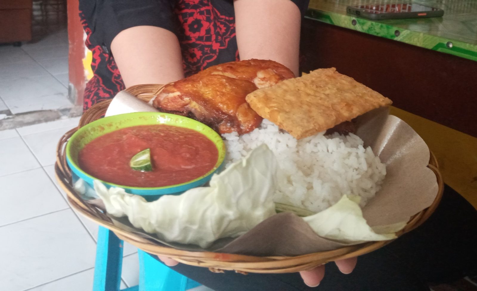 TETAP RAMAI: Seorang pengunjung menyajikan makanan yang dihidangkan di Warung Kamboja, Jalan Kamboja, Kota Mataram, kemarin. Warung ini selalu ramai ditengah pandemi Covid-19.( ROJAI/LOMBOK POST)