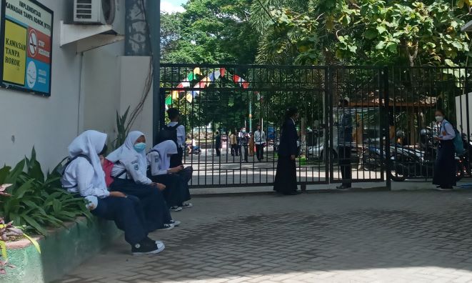 TUNGGU JEMPUTAN:  Sejumlah siswa SMPN 6 Mataram tidak diizinkan pulang sebelum orang tuanya datang menjemput di sekolah setempat, kemarin (6/8/21). (R JAI/LOMBOK POST)