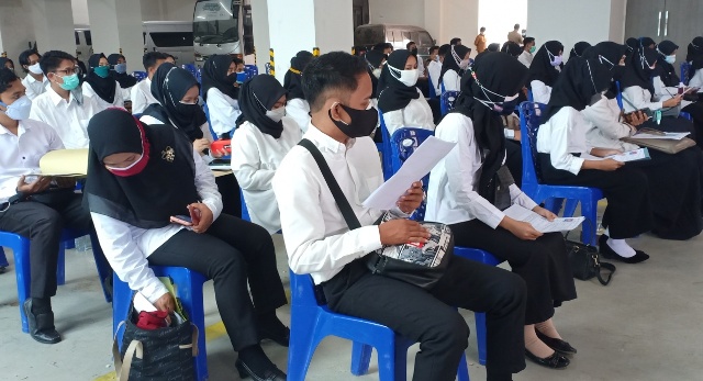 MENGANTRE: Para peserta seleksi CPNS Loteng saat menunggu giliran masuk ke ruang tes SKD di halaman parkir VIP kantor bupati, Senin (20/9). (Dedi/Lombok Post)