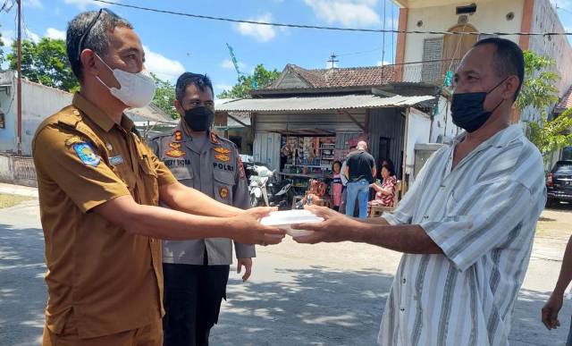 DAPAT NASI KOTAK: Camat Praya Mastur saat menyerahkan nasi kotak kepada warga di Praya usai divaksin di jalan raya kantor Gapensi Loteng, Senin (11/10). (Dedi/Lombok Post)