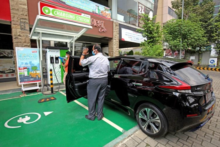 Petugas mengisi daya mobil listrik di Stasiun Pengisian Kendaraan Listrik Umum (SPKLU) di kawasan MT haryoni, Jakarta, Kamis (5/8/2021). PT Pertamina (Persero) bersama dengan Badan Pengkajian dan penerapan Teknologi (BPPT) resmi mengoperasikan SPKLU fast