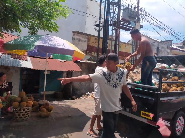 POTENSI DIKEMBANGKAN: Para pekerja tengah menurunkan durian dari bak mobil terbuka, kemarin (7/11). (ZAD/LOMBOK POST )