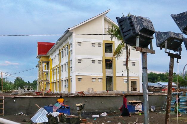 HARUS TUNTAS: Seorang warga berjalan disamping area pembangunan Rusunawa Nelayan di Kelurahan Bintaro, Kecamatan Ampenan, Kota Mataram, kemarin. Proyek ini harus tuntas akhir bulan ini. (IVAN/LOMBOK POST)