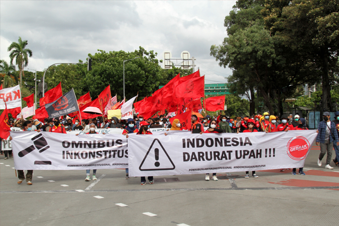 Buruh dari berbagai aliansi menggelar unjuk rasa menolak besaran kenaikan Upah Minimum Provinsi (UMP) dan UU Omnibus Law di depan Balai Kota DKI Jakarta, Senin (29/22/2021). Dalam aksinya para buruh menolak penetapan UMP yang tertuang dalam Peraturan Peme