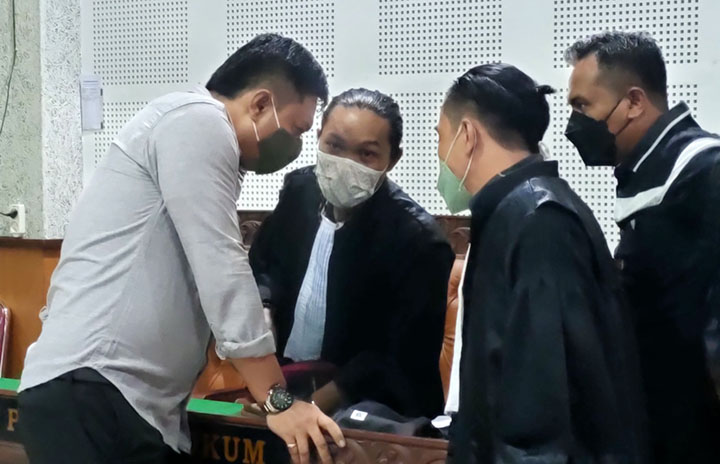 SIAPKAN STRATEGI: Terdakwa L Ihwanul Hubi (kiri) berdiskusi dengan penasihat hukumnya usai menjalani sidang di PN Tipikor Mataram, Selasa (28/12). (Harli/Lombok Post)