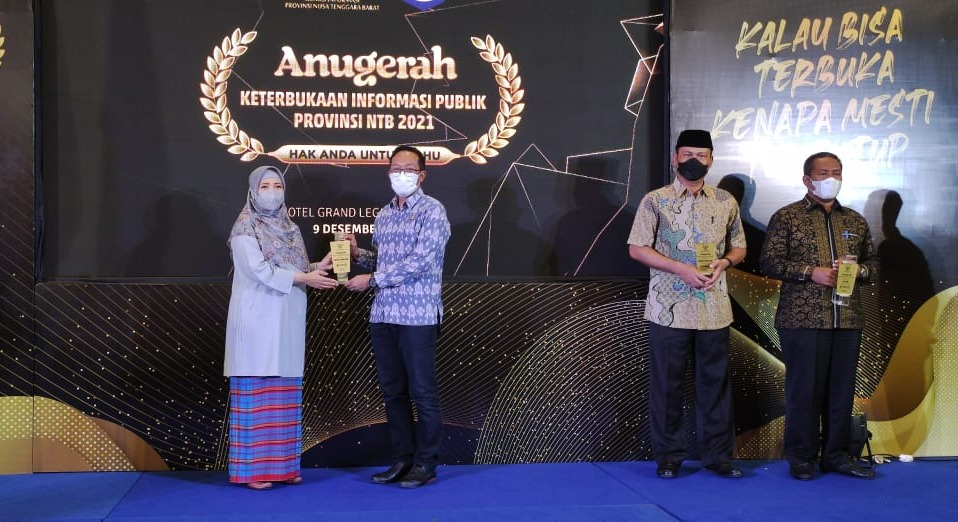 RAIH JUARA: Wagub NTB Hj Siti Rohmi Djalilah (kiri) menyerahkan penghargaan kepada Sekda Lotim HM Juaini Taofik pada acara Anugerah Keterbukaan Informasi Publik 2021 NTB di Hotel Grand Legi Mataram, Kamis (9/12).