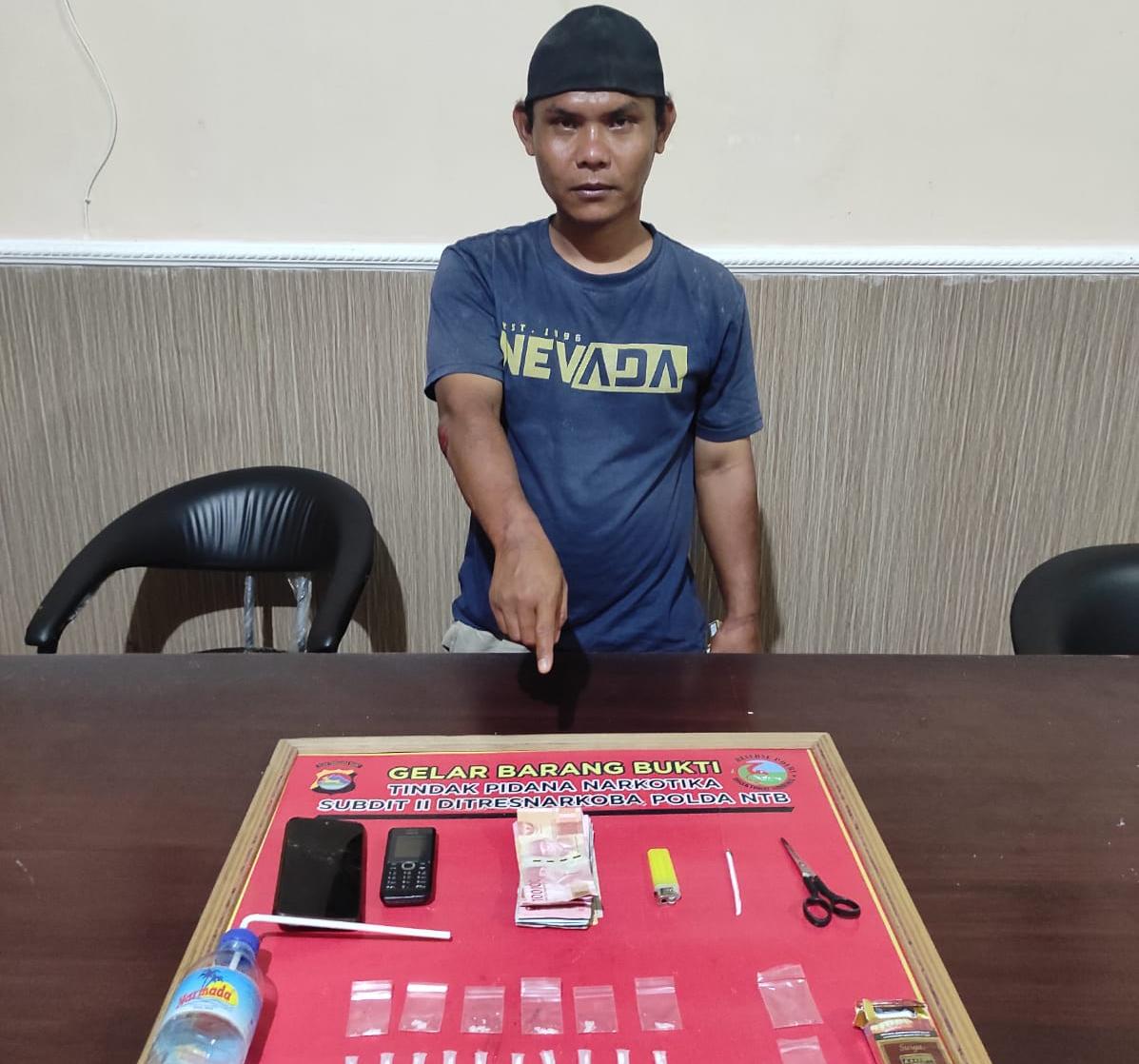 TAK BERKUTIK: Terduga pengedar sabu berinisial SW alias Win menunjukkan barang bukti sabu usai ditangkap tim Ditresnarkoba Polda NTB, Kamis malam (9/12). (Ditresnarkoba Polda NTB for Lombok Post)