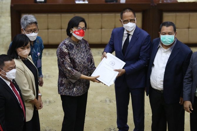 Ketua Komisi XI DPR RI Dito Ganintudo (kedua kanan) menyerahkan Daftar Investarisasi Masalah (DIM) RUU HKPD kepada Menteri Keuangan Sri Mulyani (keempat kiri) dalam rapat kerja Komisi XI DPR RI dengan Menteri Keuangan di Kompleks Parlemen, Senayan, Jakart