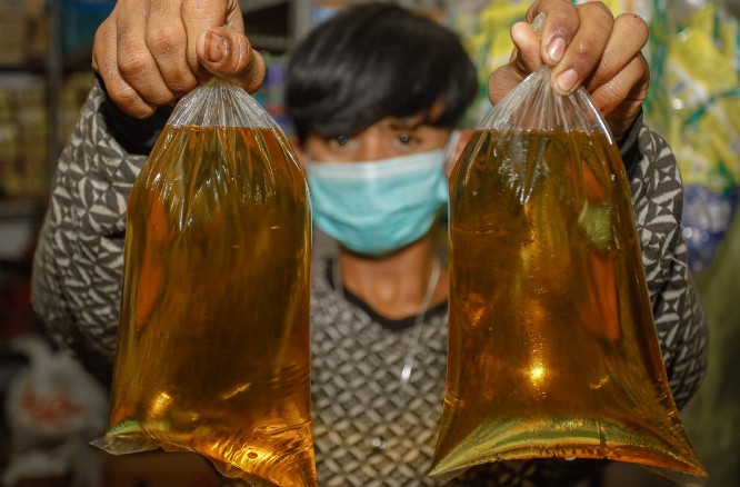 Seorang pedagang minyak goreng curah di pasar. (Dipta Wahyu/JawaPos)