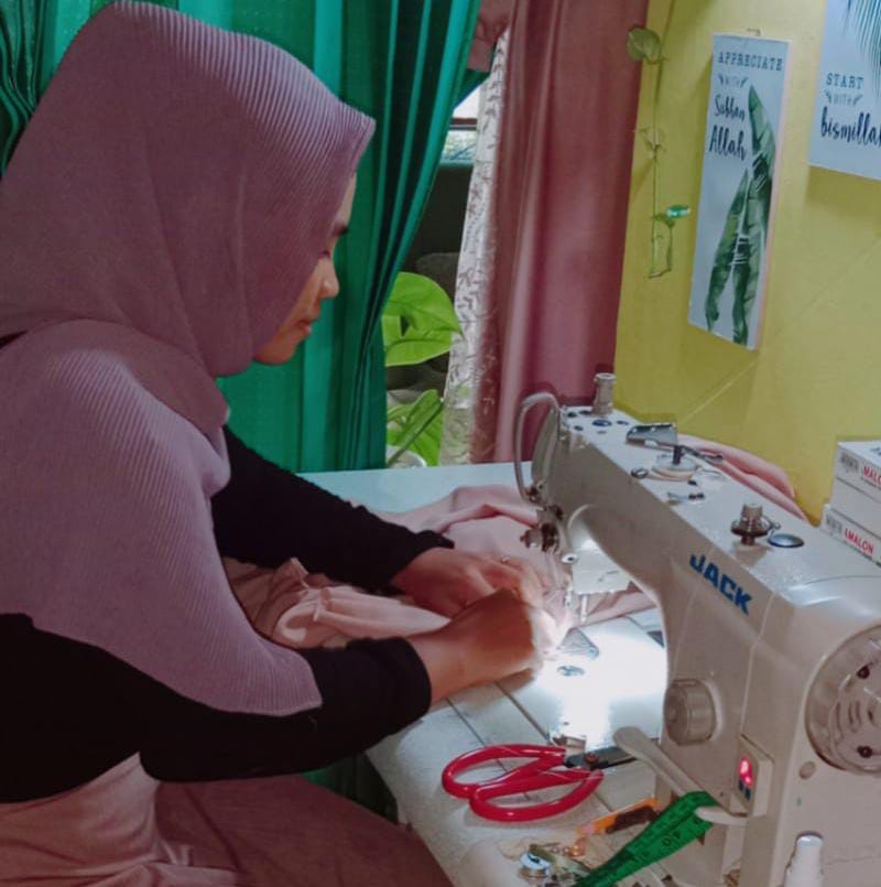 USAHA JAHIT RUMAHAN: Larasati menyelesaikan orderan jahit pakaian di kediamannya, Kamis (9/12/2021).