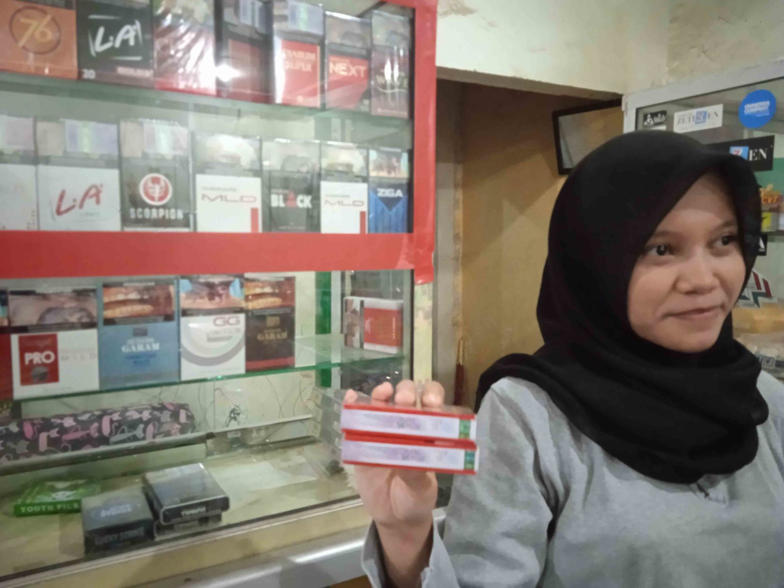 ILUSTRASI: Seorang pedagang ritel menunjukkan deretan rokok yang dijual di etalase tokonya