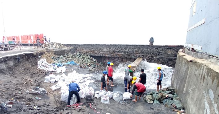 CEGAH SEMAKIN PARAH: Sejumlah pekerja dari PT Pertamina Terminal Ampenan saat berusaha menutupi lubang yang keropos diterjang gelombang pasang di lokasi Anjungan Pantai Ampenan, kemarin (27/1).( TONI/LOMBOK POST)