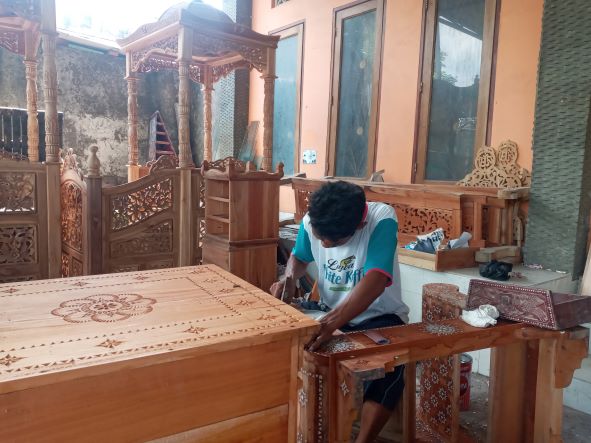 KERAJINAN CUKLI: Mustaal, seorang perajin cukli memasang kulit kerang pada kerajinan ukiran kursi di Artshop Rafsan Lingkungan Rungkang Jangkuk, Kelurahan Sayang-Sayang, Kota Mataram, belum lama ini.( ROJAI/LOMBOK POST)