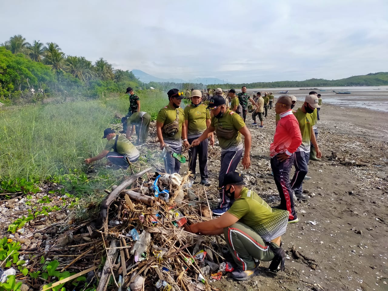 BERSIH-BERSIH: Jajaran kodim 1620 dan warga, saat menggelar aksi gotong royong membersihkan Pantai Teluk Awang Desa Mertak, Pujut, Loteng, beberapa hari lalu. (Dedi/lombok tengah  )