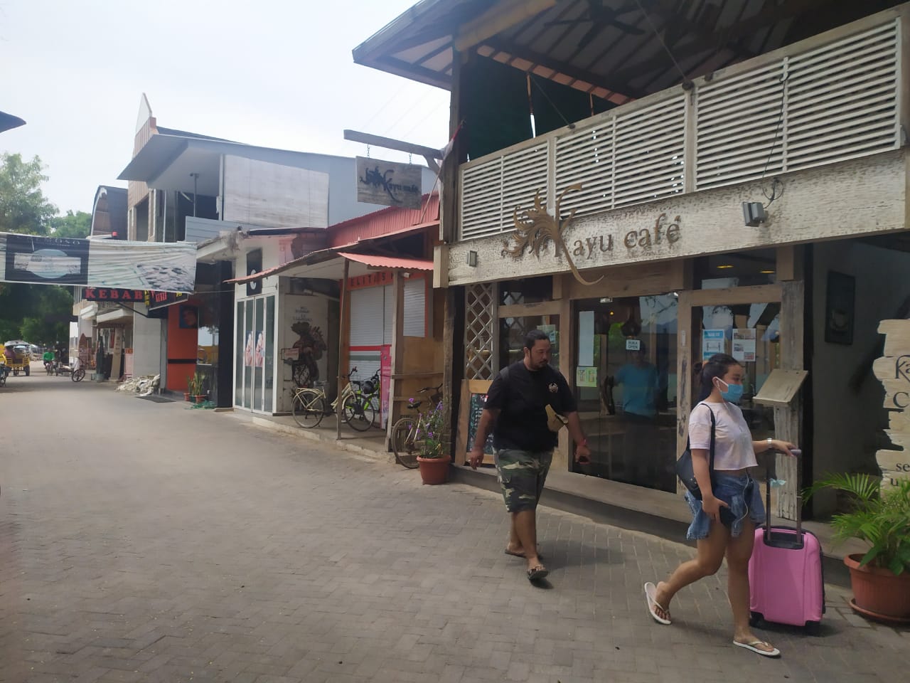 HARUS DIMAKSIMALKAN: Dua orang wisatawan berjalan  di depan salah satu restoran yang berdiri di atas lahan Pemprov NTB di Gili Trawangan, beberapa waktu lalu. (Dok/Lombok Post)