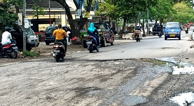 JALAN RUSAK: Sejumlah pengendara saat melewati salah satu titik jalan yang rusak di depan Pasar Renteng, Praya, Loteng, Senin (10/1). (Dedi/Lombok Post)