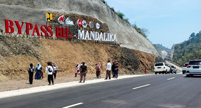 TETAP RAMAI: Para wisatawan domestik saat singgah untuk berswafoto di tulisan Bypass BIL-Mandalika, Loteng, Minggu (24/10). (Dedi/Lombok Post)