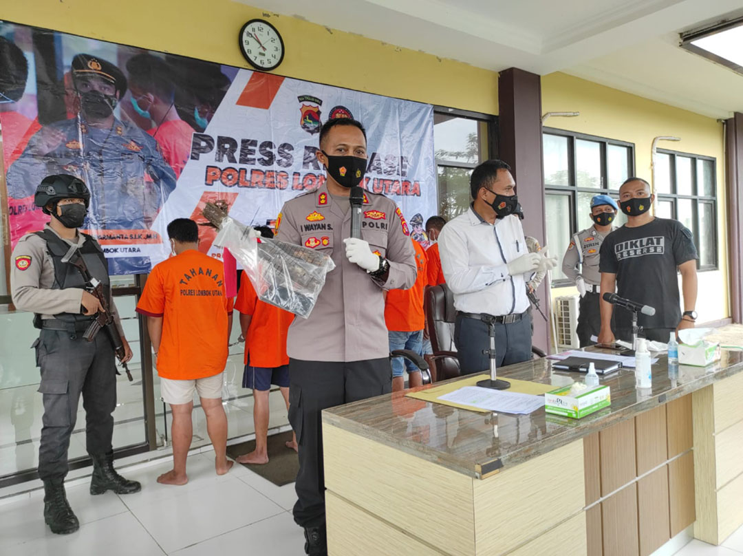 TUNJUK BARANG BUKTI: Kapolres Lotara AKBP I Wayan Sudarmanta (kiri depan) menunjukkan barang bukti kayu kering yang digunakan pelaku Curas menganiaya korbannya, dalam jumpa pers, kemarin (17/1). (FERIAL/LOMBOK POST)