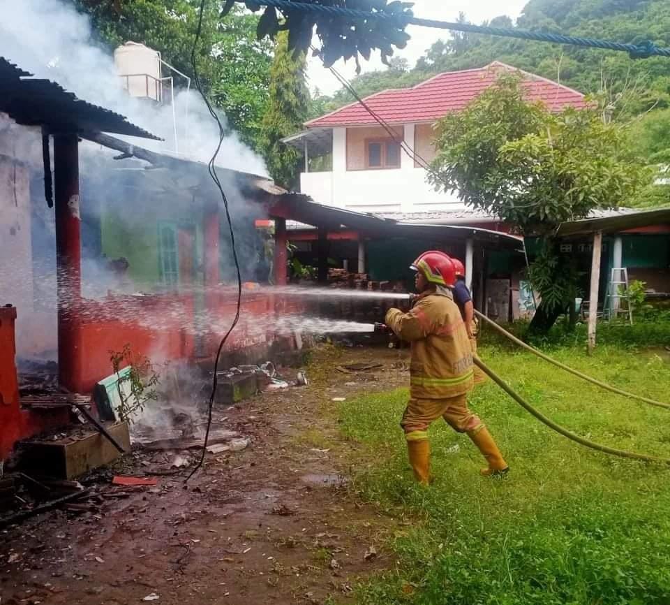 BERUSAHA PADAMKAN API: Petugas Damkar Lobar berusaha memadamkan api yang membakar rumah Ni Putu Arini di Desa Senggigi, Kecamatan Batulayar, kemarin (19/1). (Damkar Lobar For Lombok Post)