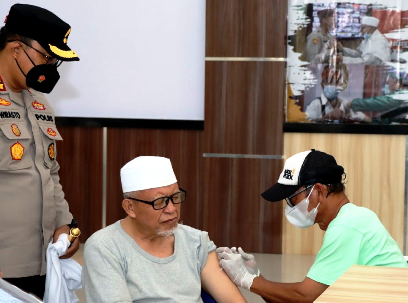 DAMPINGI VAKSIN BOOSTER: Kapolres Lobar AKBP Wirasto Adi Nugroho (kiri) mendampingi salah satu tokoh agama saat melakukan vaksin booster di Mapolres Lobar. (NURUL/LOMBOK POST)