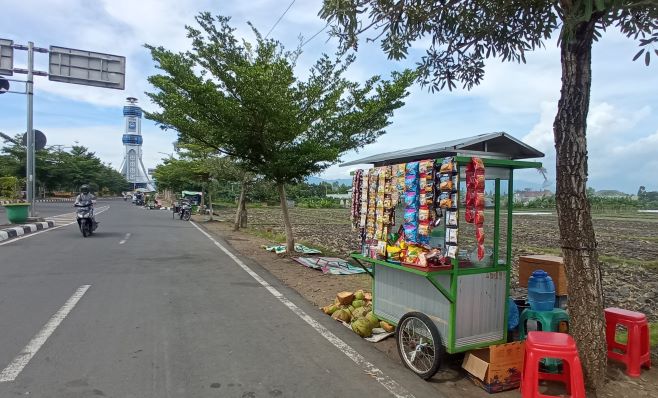 BERJUALAN: Sejumlah pedagang kaki lima kembali berjualan di area jalur by pass dekat Gerbang Tembolak hingga Bundaran Mataram Metro, Senin (11/1) lalu.( TONI/LOMBOK POST)
