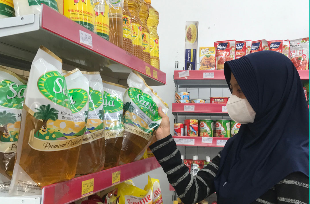 BORONG: Seorang konsumen sedang membeli minyak goreng yang dijual di ritel modern, kemarin (10/1).(EKA/LOMBOK POST)