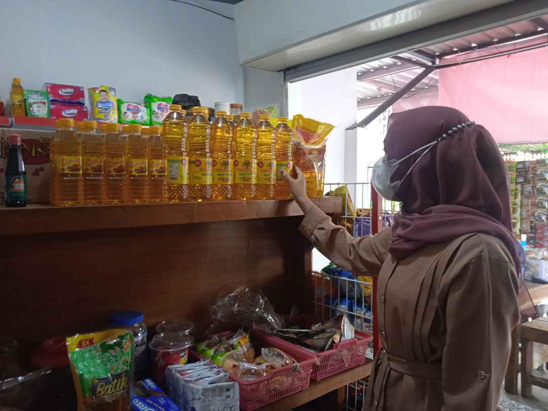 PILIH YANG MURAH: Seorang pembeli hendak membeli  minyak goreng kemasan, di salah satu kios sembako Gunungsari, Lombok Barat, kemarin (12/1). (EKA/LOMBOK POST)