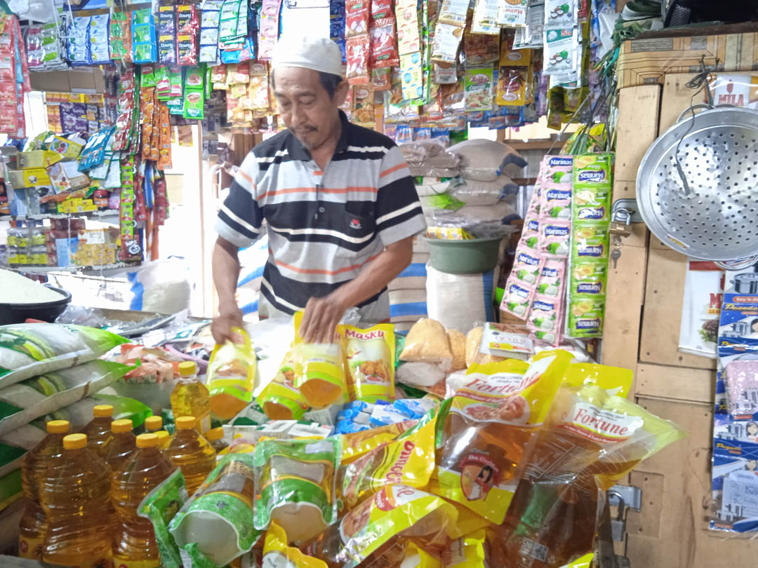 BUTUH SUBSIDI: Seorang pedagang di Pasar Kebon Roek menunjukkan sejumlah merek minyak goreng dalam kemasan yang dijual di lapaknya, Desember 2021 lalu.  (EKA/LOMBOK POST)
