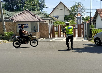 RAZIA: Seorang pemotor yang tidak menggunakan helm dihentikan polisi dalam razia di Jalan Langko, Mataram, Rabu (2/2). (Harli/Lombok Post)