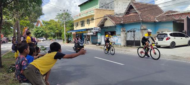 DIELU-ELUKAN WARGA: Warga Loteng melambaikan tangan ke arah pebalap sepeda L’Etape, Minggu (20/2). Mereka tampak antusias menyambut pebalap. (Habibul Adnan/Lombok Post)