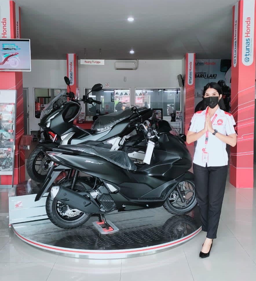 MOTOR BERKELAS: Seorang karyawan menunjukkan display Honda PCX, salah satu produk unggulan Honda, kemarin (17/2). (honda For Lombok Post)