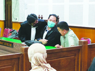 BEBAS: Terdakwa Aryanto Prametu berdiskusi dengan penasihat hukumnya saat menjalani sidang di PN Tipikor Mataram, beberapa waktu lalu. Kini dia divonis bebas oleh majelis hakim Pengadilan Tinggi NTB. (Dok/Lombok Post)