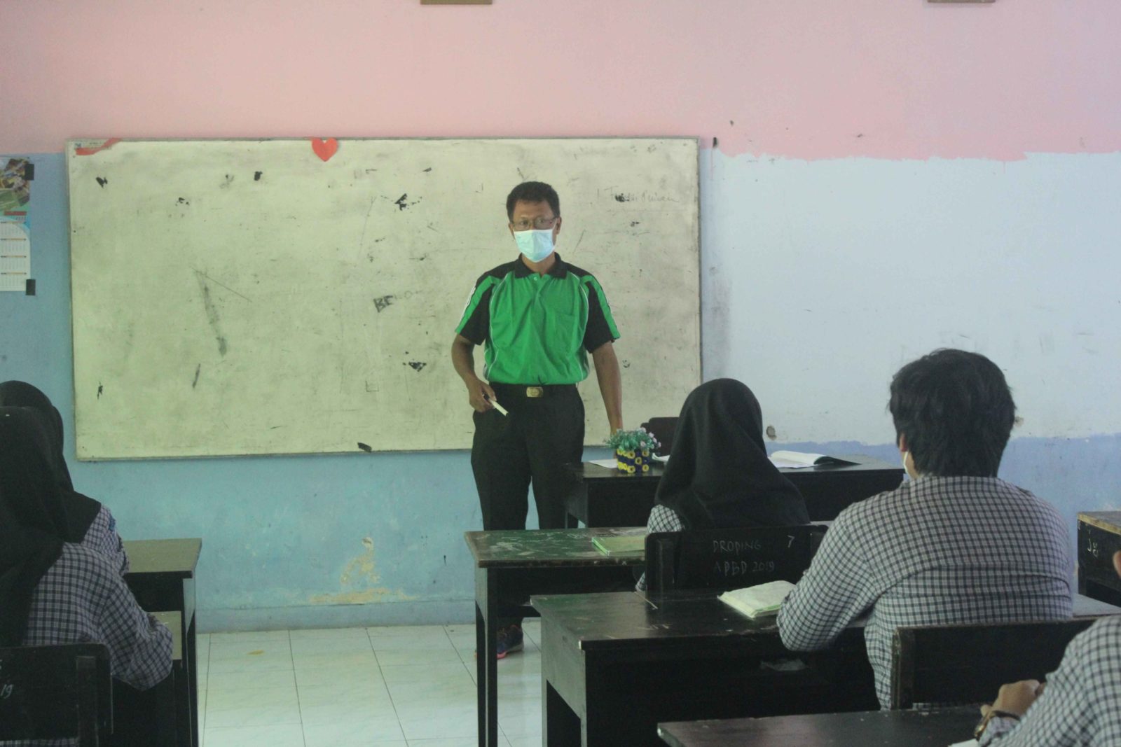 TRANSFER ILMU: Guru menjelaskan materi pelajaran, saat berlangsungnya PTM terbatas di SMPN 9 Mataram pekan lalu.