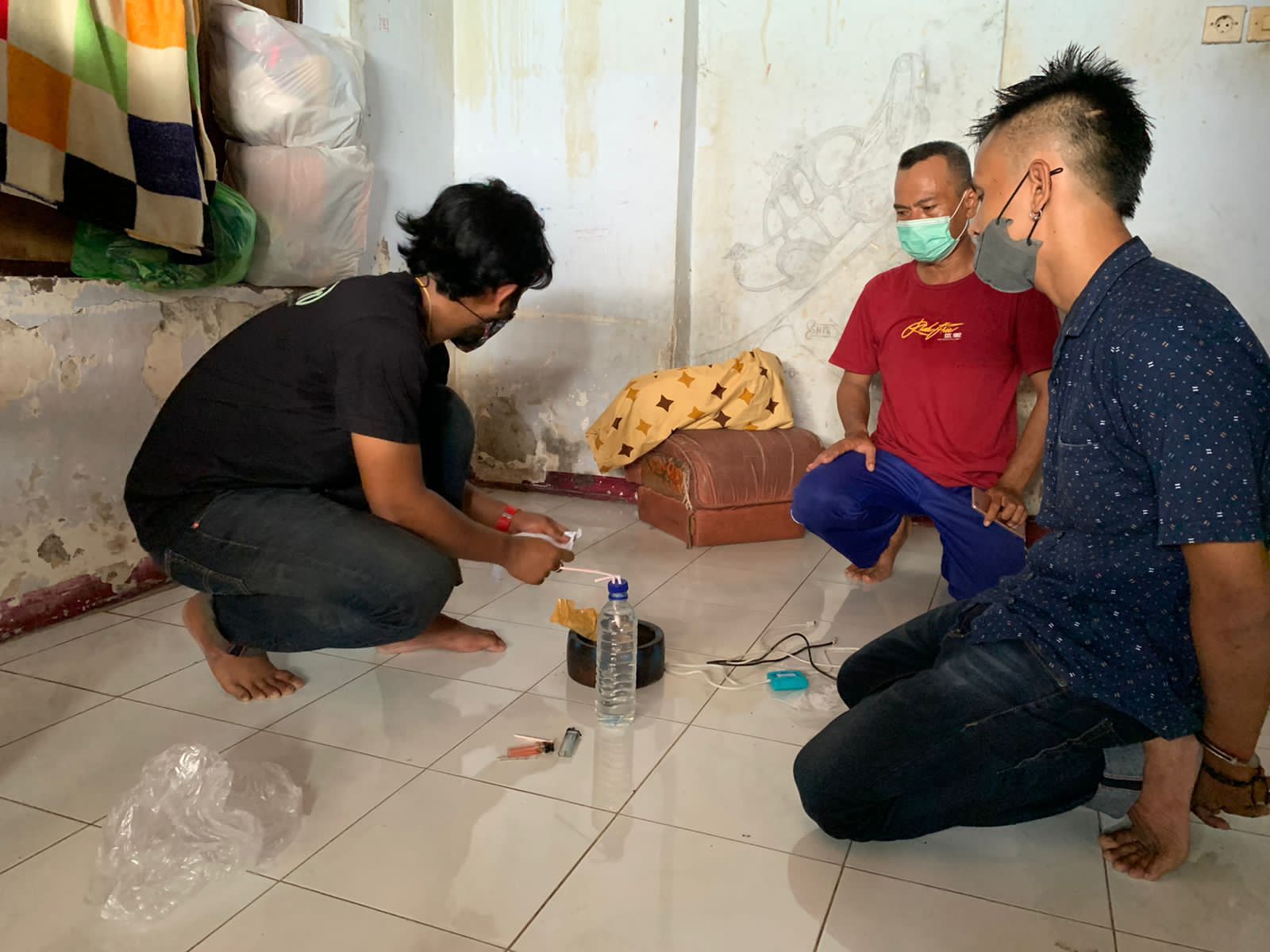 TEMUKAN BUKTI: Polisi menggeledah kamar AMP (kanan) usai ditangkap tim Satresnarkoba Polresta Mataram, Sabtu (5/2) lalu. (Harli/Lombok Post)