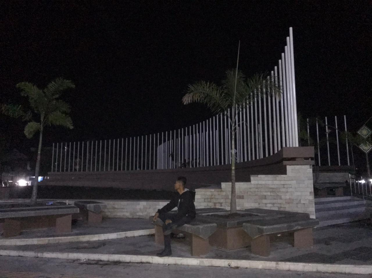 MASIH GELAP: Seorang warga Selong sedang duduk menikmati RTP Pancor yang masih dalam proses pengerjaan di Kelurahan Pancor, Kecamatan Selong, belum lama ini. (Fatih/Lombok Post)
