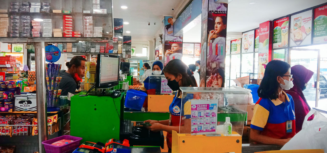 WASPADA UPAL: Salah satu kasir sedang merapikan sejumlah uang pecahan kecil ke dalam mesin kasir di salah satu ritel lokal di Kota Mataram, Rabu (20/4/2022). (Dewi/Lombok Post)