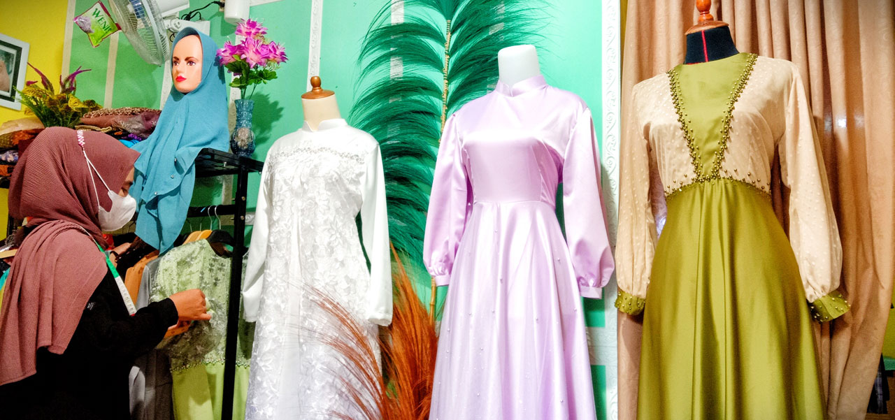 BANJIR ORDERAN: Larasati menunjukkan sejumlah hasil desain dan jahitan milik pelanggan dirumahnya, Selasa (26/4/2022). Menjelang Lebaran Idul Fitri 1443 H jasa tukang jahit kebanjiran orderan bahkan sampai kewalahan menerima pesanan banyak. (Dewi/Lombok P