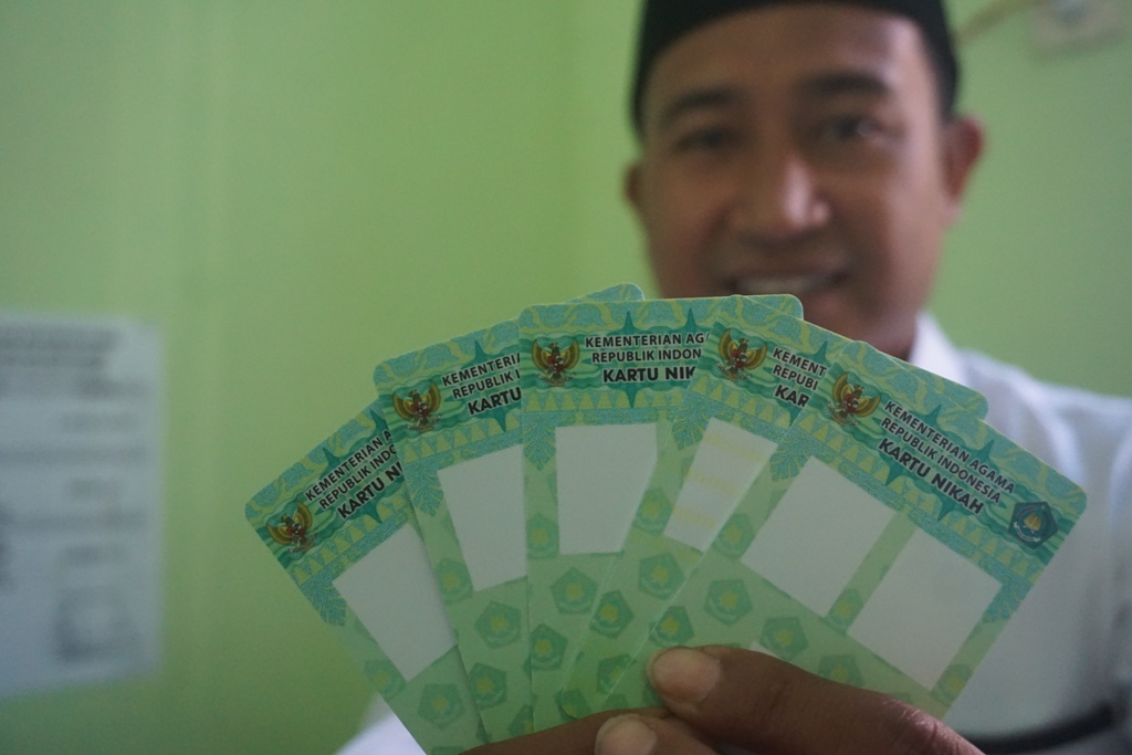 KARTU NIKAH: Petugas KUA Kecamatan Selong memperlihat blangko kartu nikah yang hendak dicetak di kantor KUA Selong, beberapa waktu lalu. (Fatih/Lombok Post)